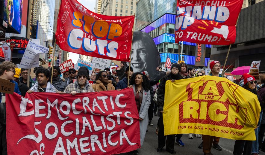 Protesters carry banners reading “Democratic Socialists of America,” “Stop the Cuts” and “Tax the Rich” during the No Kings march in New York on March 28, 2006. File photo credit: Richard Scalzo via Shutterstock.