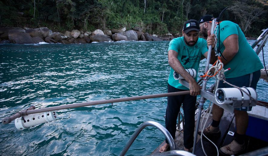 Scientific coordinator Leonardo Mitrano Neves, left, and field and logistics coordinator Daniel Shimada Brotto retrieve a Baited Remote Underwater Video System during monitoring as part of a shark project in Ilha Grande Bay, Angra dos Reis, Rio de Janeiro state, Brazil, July 14, 2026. (AP Photo/Bruna Prado)