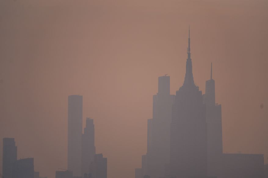 The New York City skyline is seen through a cover of wildfire smoke, in Jersey City, N.J., Friday, July 17, 2026. (AP Photo/Ryan Murphy)
