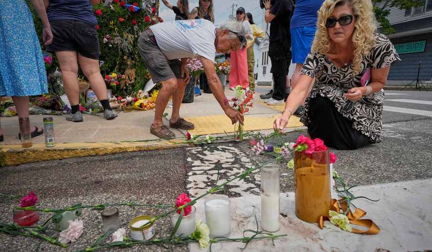 Mourners place flowers and candles in Biddeford, Maine, Wednesday, July 15 2026, near the blood-stained pavement where Johan Sebastián Durán Guerrero was pulled from his car on Monday by U.S. Immigration and Customs Enforcement agents. (AP Photo/Robert F. Bukaty)