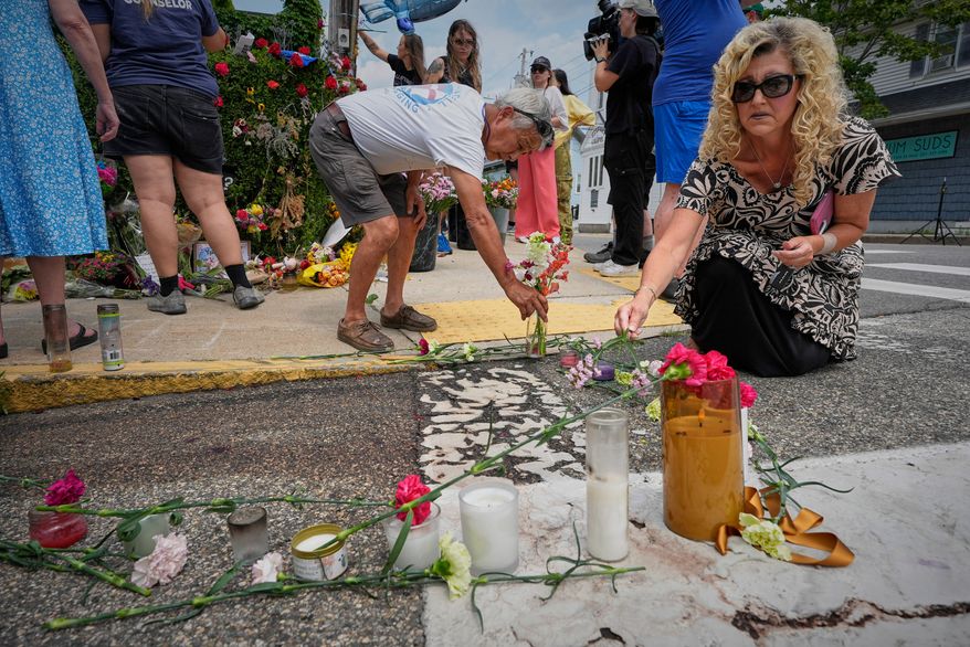 Mourners place flowers and candles in Biddeford, Maine, Wednesday, July 15 2026, near the blood-stained pavement where Johan Sebastián Durán Guerrero was pulled from his car on Monday by U.S. Immigration and Customs Enforcement agents. (AP Photo/Robert F. Bukaty)