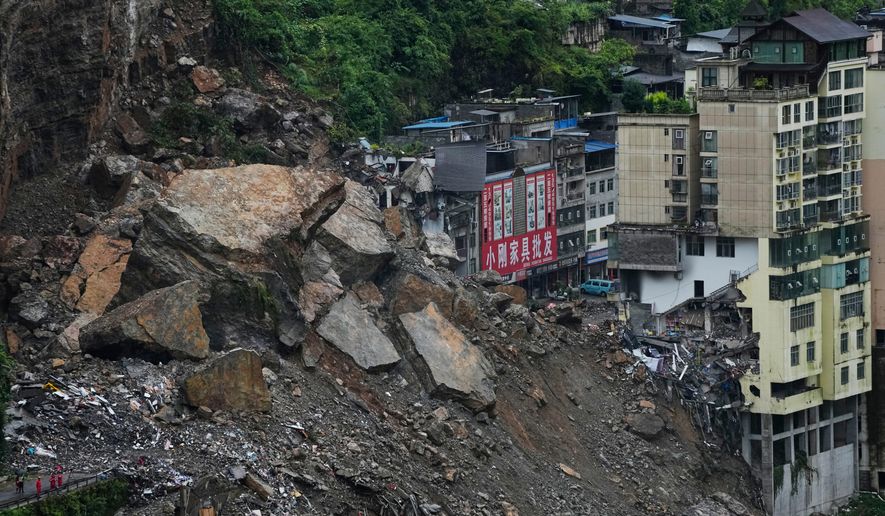 Residential and business buildings damaged by fallen rocks and mud are seen after a landslide in Pengshui County in southwestern China's Chongqing on Saturday, July 18, 2026. (AP Photo/Andy Wong)