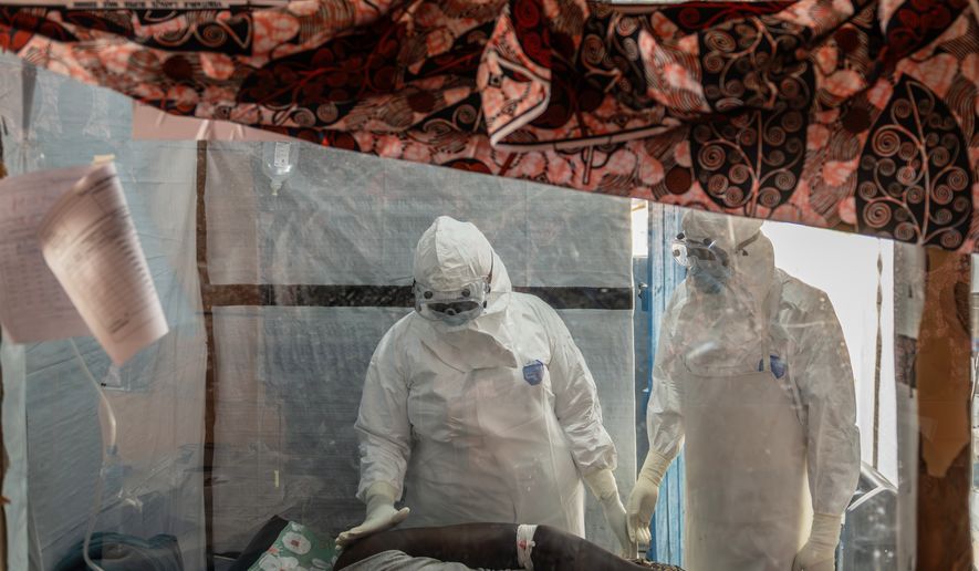 Health workers tend to an Ebola patient at the Rwampara Treatment Center in Ituri, Congo, Thursday, June 18, 2026. (AP Photo/Moses Sawasawa)