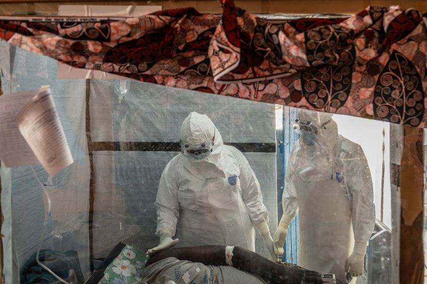 Health workers tend to an Ebola patient at the Rwampara Treatment Center in Ituri, Congo, Thursday, June 18, 2026. (AP Photo/Moses Sawasawa)