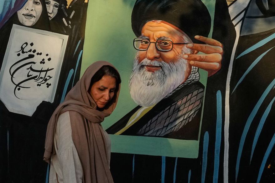 A woman walks past a mural depicting a portrait of the late Iranian Supreme Leader Ayatollah Ali Khamenei, who was killed in the U.S. and Israel strike on Feb. 28, in downtown Tehran, Iran, Saturday, July 18, 2026. (AP Photo/Vahid Salemi)