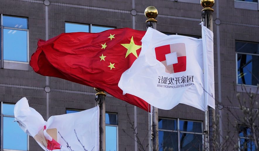 FILE - Flags of the China Development Bank are flown near a Chinese flag outside a subsidiary branch office of the Bank in Beijing, Jan. 8, 2021. (AP Photo/Ng Han Guan, File)