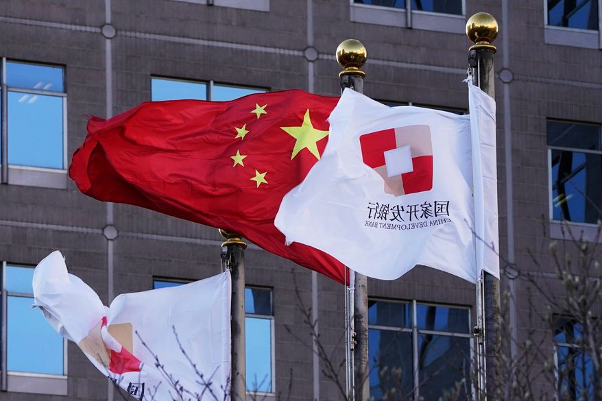 Flags of the China Development Bank are flown near a Chinese flag outside a subsidiary branch office of the Bank in Beijing, Jan. 8, 2021. (AP Photo/Ng Han Guan, File)