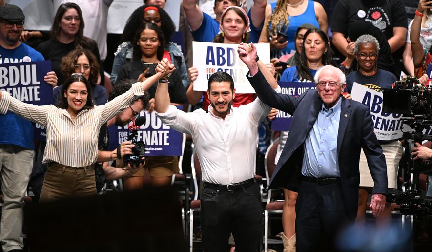 From left foreground, U.S. Rep. Alexandria Ocasio-Cortez, D-N.Y., Michigan Democratic U.S. Senate primary candidate Abdul El-Sayed, and U.S. Sen. Bernie Sanders, I-VT. join hands together following a campaign rally, Saturday, July 18, 2026, in Detroit. (AP Photo/Jose Juarez)
