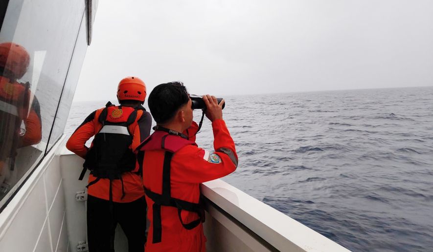 In this photo released by Makassar Search and Rescue Office on Sunday, July 19, 2026, rescuers scan the horizon as they search for victims after a passenger boat sank in the waters near Selayar Islands in South Sulawesi, Indonesia. (Makassar SAR Office via AP)