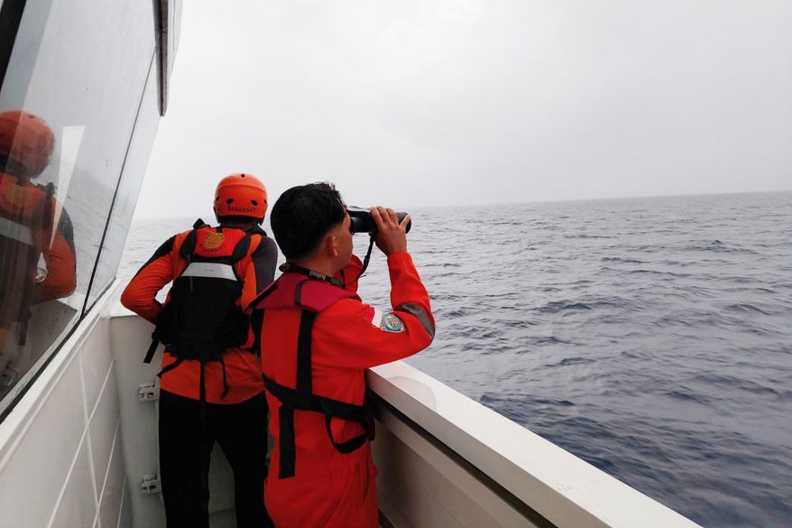In this photo released by Makassar Search and Rescue Office on Sunday, July 19, 2026, rescuers scan the horizon as they search for victims after a passenger boat sank in the waters near Selayar Islands in South Sulawesi, Indonesia. (Makassar SAR Office via AP)