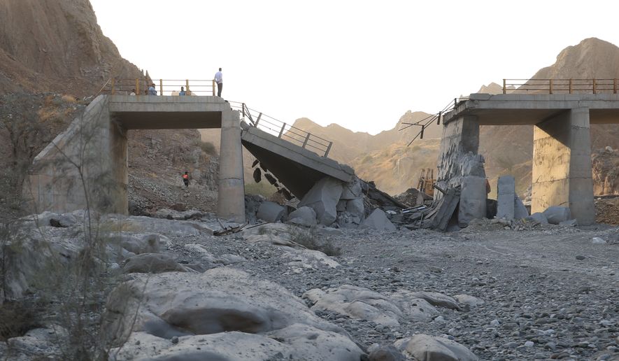 People stand on a bridge destroyed after a strike in Hormozgan province, southern Iran, Saturday, July 18, 2026. (Amirhosein Khorgooi/Iranian Students' News Agency via AP)