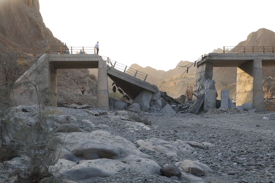 People stand on a bridge destroyed after a strike in Hormozgan province, southern Iran, Saturday, July 18, 2026. (Amirhosein Khorgooi/Iranian Students' News Agency via AP)