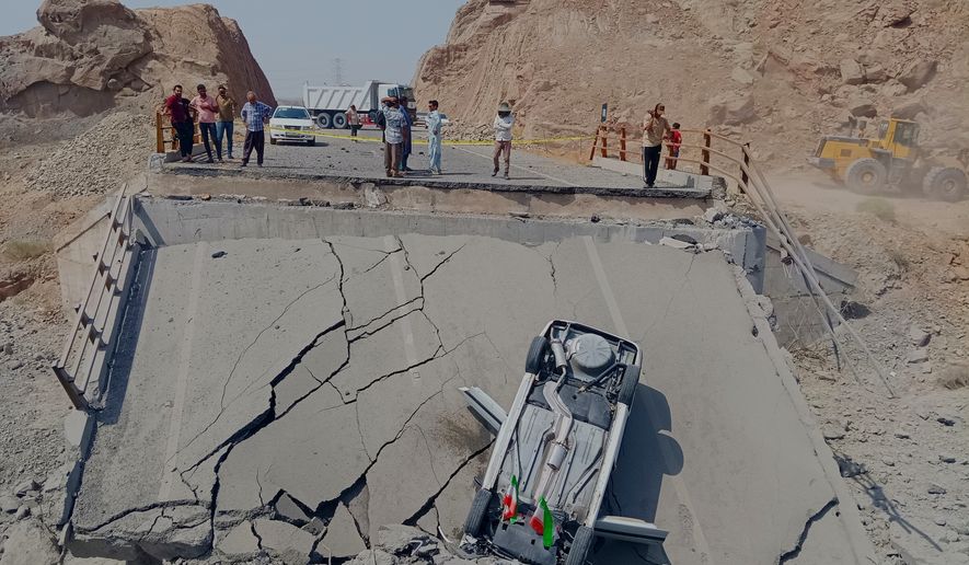 An overturned car sits on a section of a destroyed bridge after a strike in Hormozgan province, southern Iran, Saturday, July 18, 2026. (Mahdi Negahban/Mehr News Agency via AP)