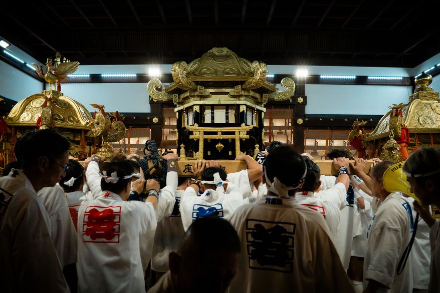 Festival participants carry Yasaka Shrine's Eastern Mikoshi back into the shrine's main hall following the "Mikoshi Arai" purification ritual ahead of the Gion Matsuri festival in Kyoto, western Japan, Friday, July 10, 2026. (AP Photo/Fred Mery)