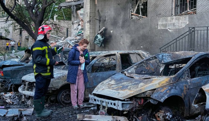 An owner looks at her damaged car following a Russia missile attack in Kyiv, Ukraine, Sunday, July 19, 2026. (AP Photo/Efrem Lukatsky)
