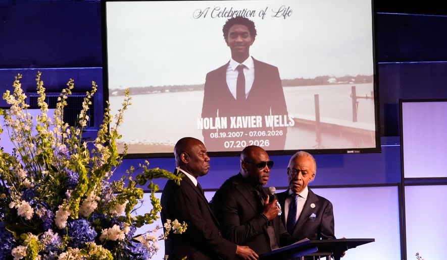 Elmore Wonsley, center, speaks next to attorney Ben Crump, left, and Rev. Al Sharpton during a memorial service for Nolan Xavier Wells, an 18-year-old found dead after taking a July 4 boat trip with friends, Monday, July 20, 2026, in Ocean Springs, Miss. (AP Photo/Gerald Herbert)