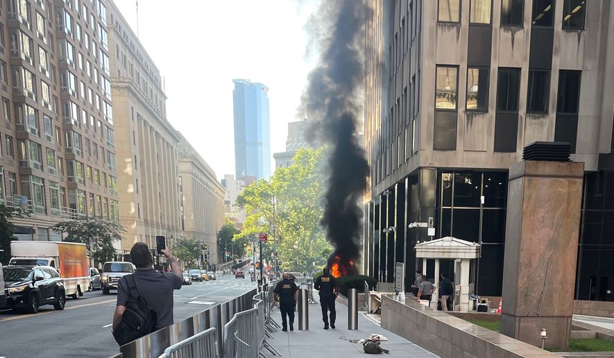 This photo provided by Robert Sullivan shows black smoke and flames in front of 26 Federal Plaza in lower Manhattan, Monday, July 20, 2026, in New York. (Robert Sullivan via AP)