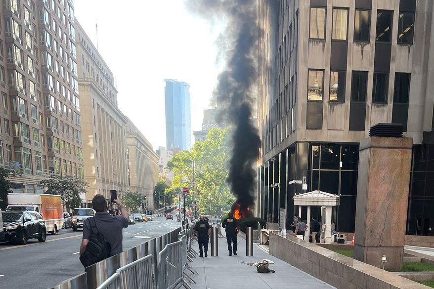 This photo provided by Robert Sullivan shows black smoke and flames in front of 26 Federal Plaza in lower Manhattan, Monday, July 20, 2026, in New York. (Robert Sullivan via AP)