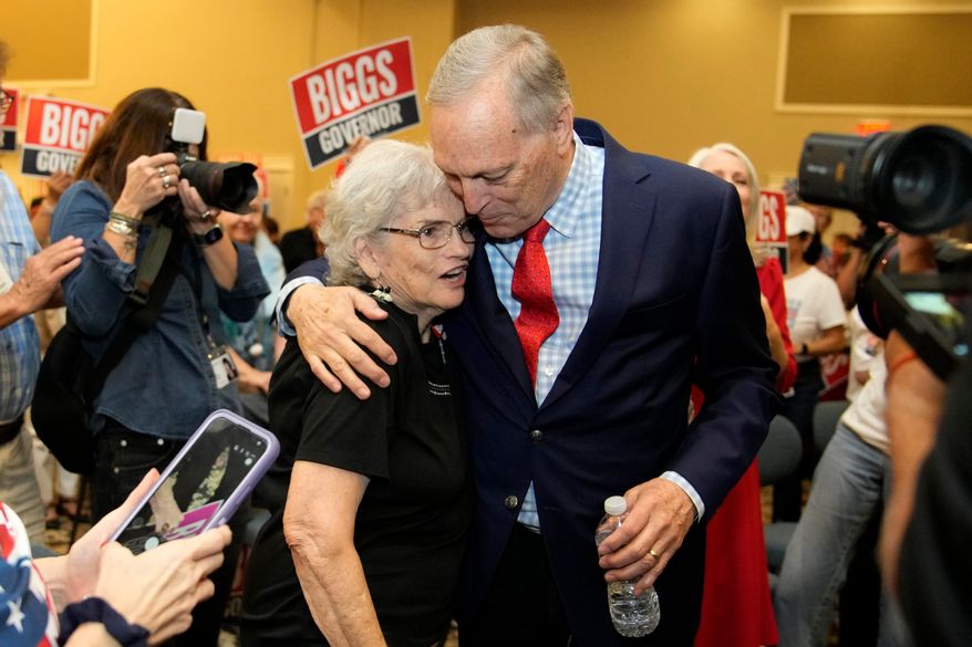 Rep. Andy Biggs, right, R-Ariz., who is running in the primary for Arizona governor, hugs a supporter at a campaign event, Friday, July 17, 2026, in Gilbert, Ariz. (AP Photo/Ross D. Franklin)