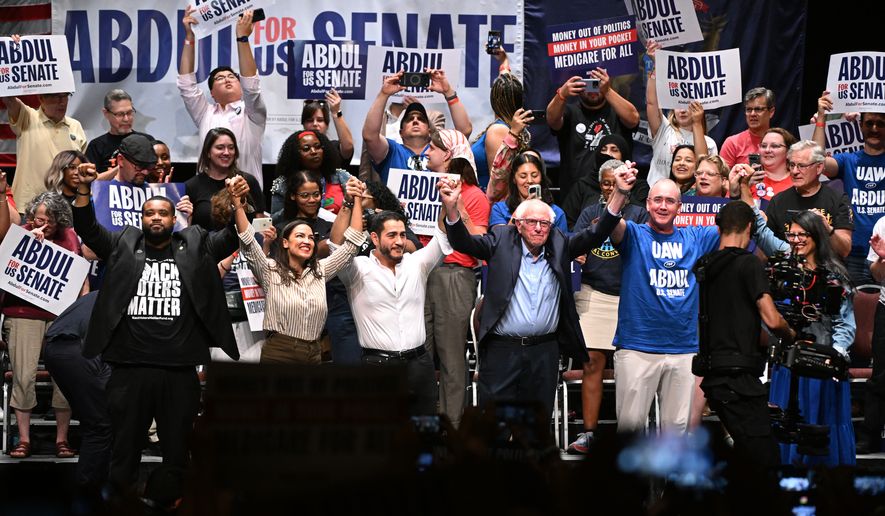 From left foreground, Michigan state Rep. Donavan McKinney, D-Detroit, U.S. Rep. Alexandria Ocasio-Cortez, D-N.Y., Michigan Democratic U.S. Senate primary candidate Abdul El-Sayed, U.S. Sen. Bernie Sanders, I-VT., United Auto Workers President Shawn Fain, and U.S. Rep. Rashida Tlaib, D-Mich. join hands together following a campaign rally for El-Sayed, Saturday, July 18, 2026, in Detroit. (AP Photo/Jose Juarez)