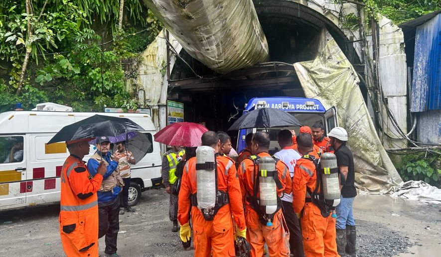 Members of the rescue team carry oxygen cylinders outside the entrance to an under-construction tunnel at a hydropower project in Samardung village, about 40 kilometers (25 miles) from Gangtok, India, Tuesday, July 21, 2026. (AP Photo)