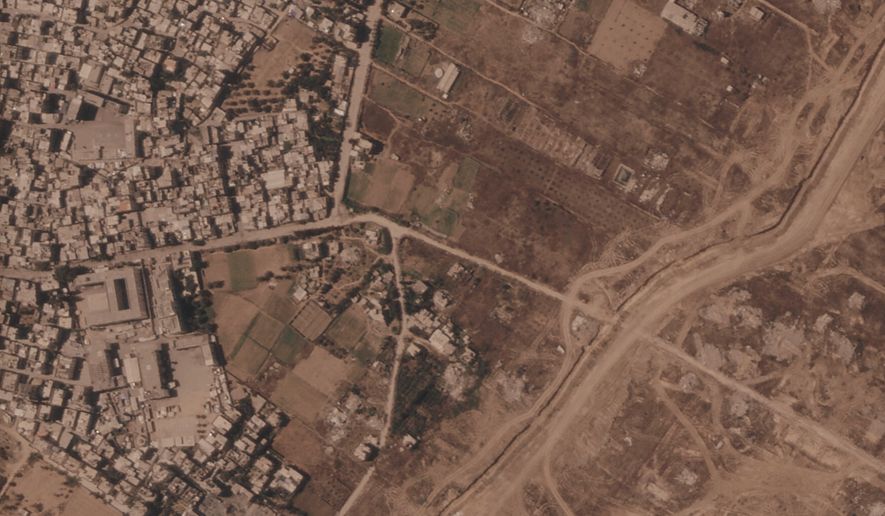This satellite image from Planet Labs PBC shows a section of an earthen barrier being built by the Israeli military, right side of image moving top to bottom, in the central Gaza Strip, July 1, 2026. At left is the Maghazi refugee camp, and on the other side are homes demolished by the military. (Planet Labs PBC via AP)