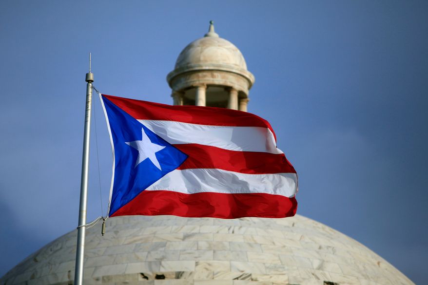 A Puerto Rican national flag flies in front of the Capitol building in San Juan, Puerto Rico, July 29, 2015. (AP Photo/Ricardo Arduengo, File)