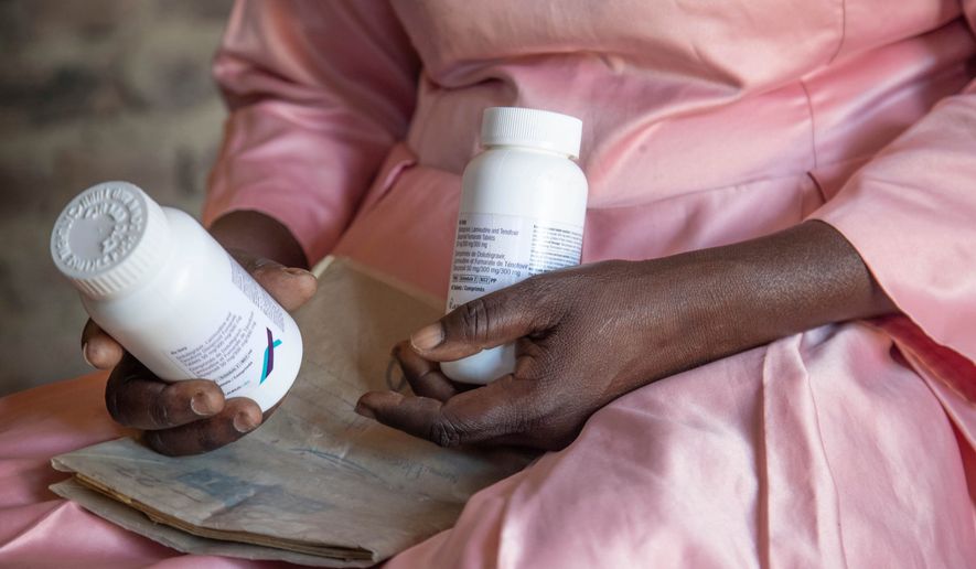 FILE - Florence Makumene holds HIV medication that she received through funding from the U.S. President's Emergency Plan for AIDS Relief (PEPFAR), along with her hospital records book, at her home in Harare, Zimbabwe, Feb. 7, 2025. (AP Photo/Aaron Ufumeli, File)