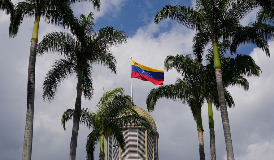 A Venezuelan flag waves in the wind atop the National Assembly palace in Caracas, Venezuela, Jan. 20, 2026. (AP Photo/Matias Delacroix, File)