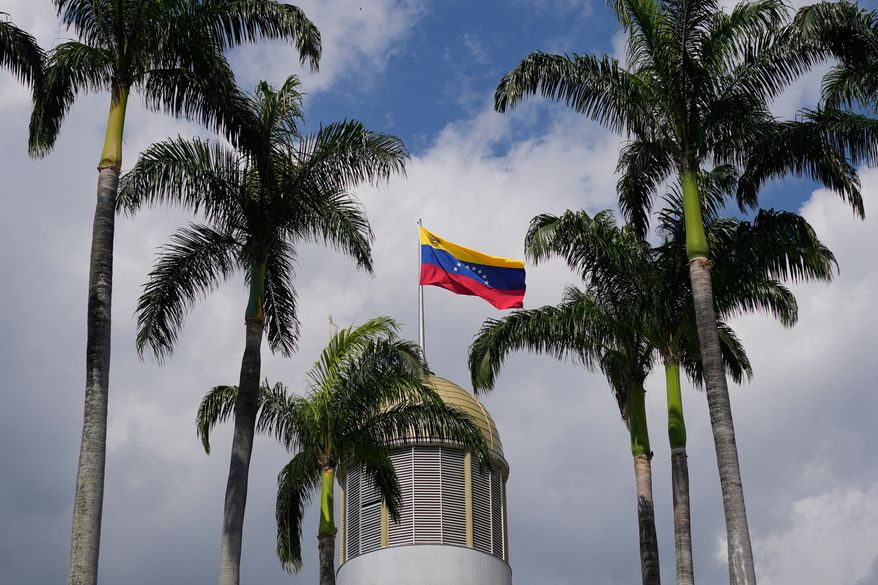 A Venezuelan flag waves in the wind atop the National Assembly palace in Caracas, Venezuela, Jan. 20, 2026. (AP Photo/Matias Delacroix, File)