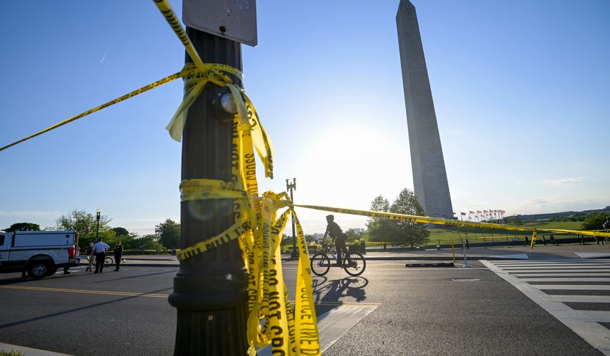 FILE - Police tape remains around the scene after a person was shot near the Washington Monument in May 4, 2026, in Washington. (AP Photo/Rod Lamkey Jr., File)