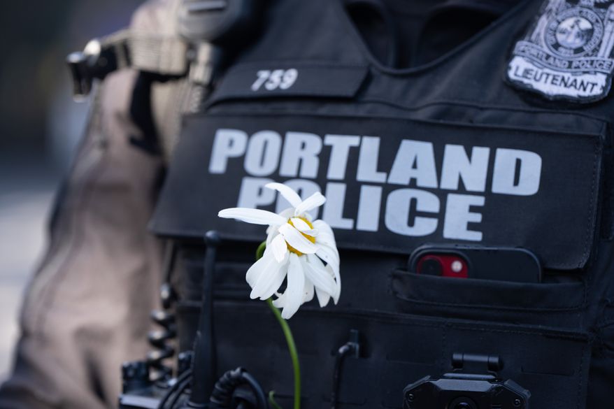 A Portland Police officer is seen during a "No Kings" protest in Portland, Ore., on Saturday, Oct. 18, 2025. (AP Photo/Jenny Kane)