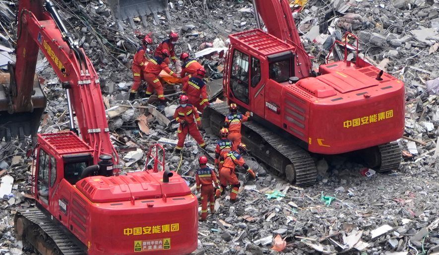 Rescuers recover a trapped victim from the rubble at the scene of a landslide in Pengshui County in southwestern China's Chongqing area on Sunday, July 19, 2026. (AP Photo/Andy Wong)