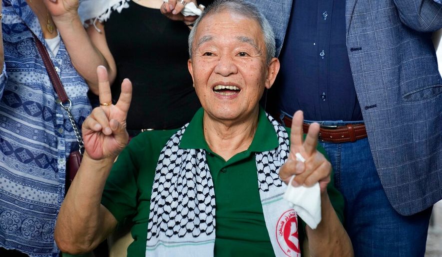 FILE - Kozo Okamoto, 74, a member of the Japanese Red Army guerrilla group, gives the victory sign to supporters as he arrives at a Palestinian cemetery to visit a memorial for four Japanese who died in support of Palestinians, in Beirut, Lebanon, Monday, May 30, 2022. (AP Photo/Hassan Ammar, File)