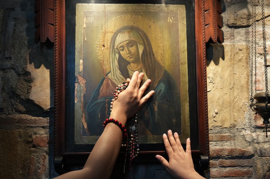 Catholics touch one of the images of Mary inside the Ephesus House, a replica of the House of the Virgin Mary in Ephesus, Turkey, at Alfonso town, Cavite province, Philippines on July 16, 2026. (AP Photo/Aaron Favila)