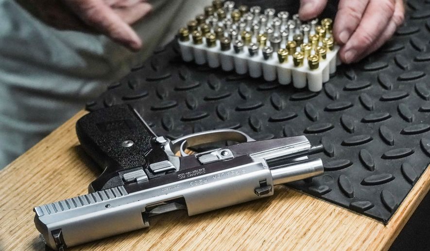 The owner of a shooting range prepares to load bullets in his 9mm semi-automatic handgun for a demonstration on June 23, 2022, in New York. (AP Photo/Bebeto Matthews, File)