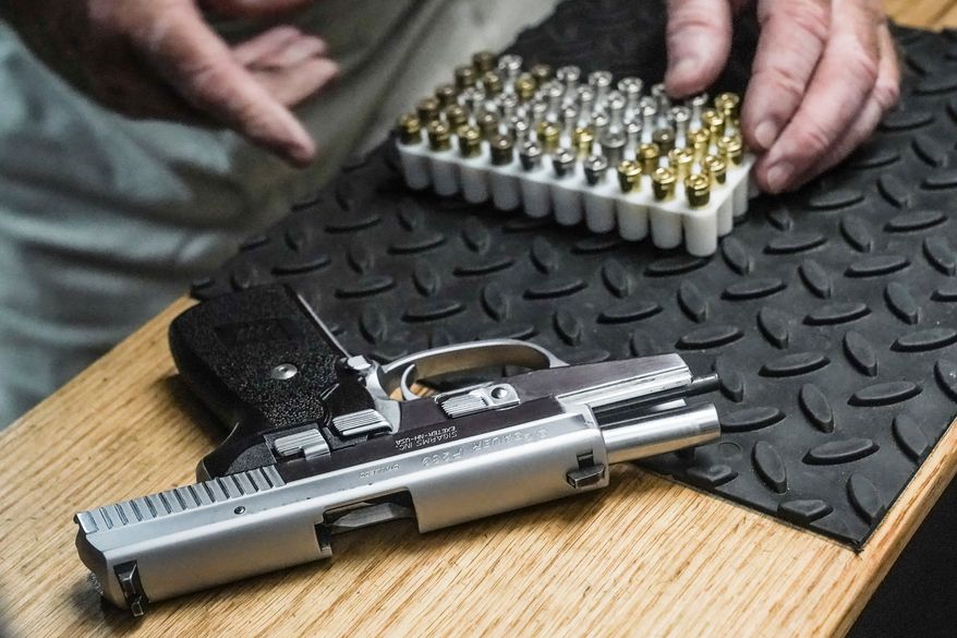 The owner of a shooting range prepares to load bullets in his 9mm semi-automatic handgun for a demonstration on June 23, 2022, in New York. (AP Photo/Bebeto Matthews, File)