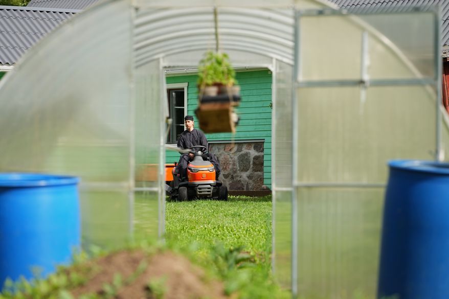 Estonia Monastery Rev. Paisios drives a riding lawn mower at the newly founded Kirikla Orthodox Monastery in Pihali village, Estonia, on July 4, 2026. (AP Photo/Sergei Grits)
