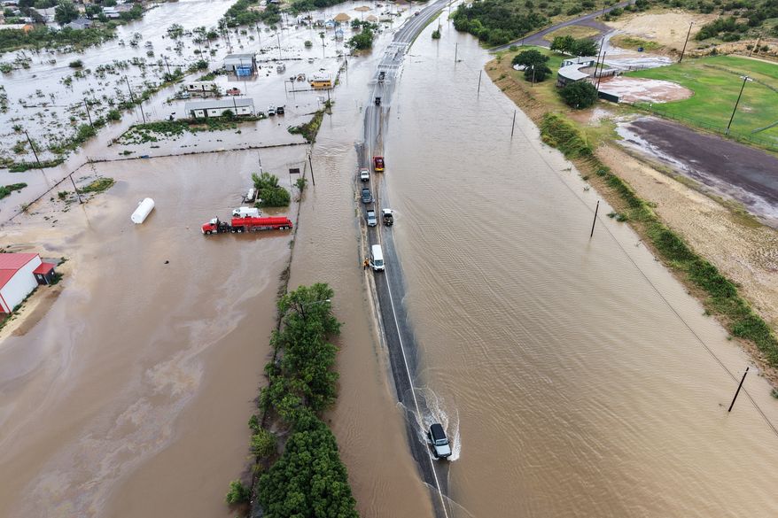 An aerial view shows flooding on Friday, July 17, 2026, in Ozona, Texas. (AP Photo/Gerald Herbert)