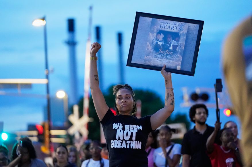 A protester holds a photo of Corey Durell Ruiz as they march Thursday, July 23, 2026, in Madison, Wis., after he was shot and killed by a Madison police officer on Wednesday. (AP Photo/Kayla Wolf)