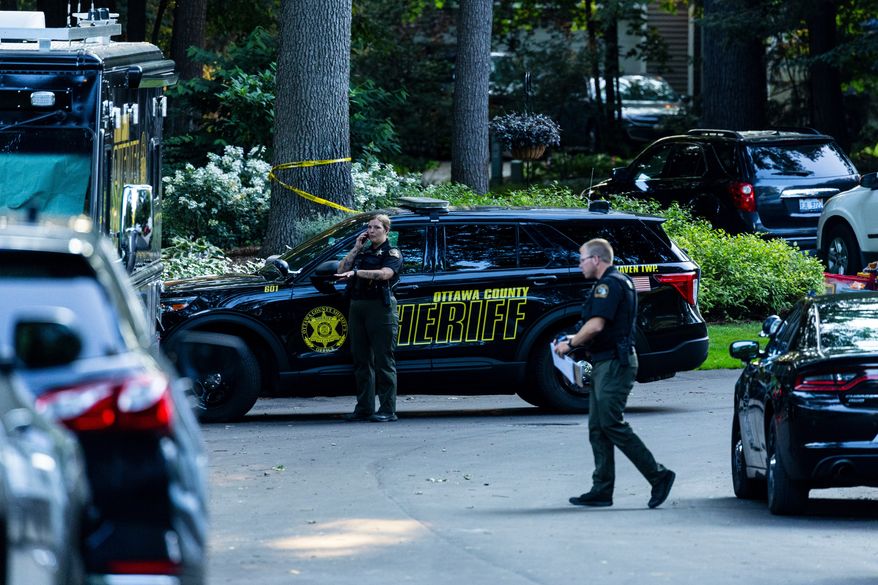 Law enforcement investigate the scene of a fatal house fire on Friday, July 24, 2026, in the in Grand Haven Township, Mich. Ottawa County Sheriff's Office said six children and two adults were found dead in a "suspicious" house fire. (Joel Bissell/Kalamazoo Gazette via AP)