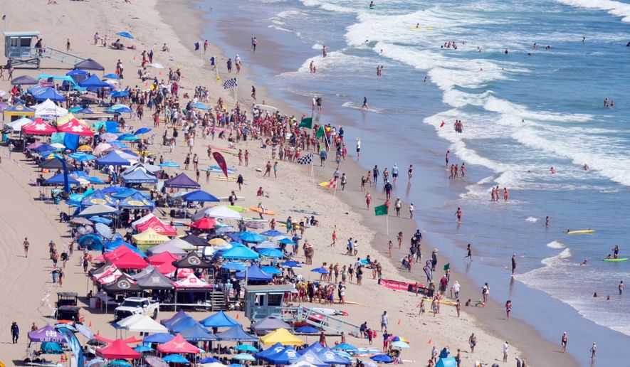 Beach goers watch during the the 46th Annual California Surf Lifesaving Championships on Will Rogers State Beach Friday, July 24, 2026, in the Pacific Palisades section of Los Angeles. (AP Photo/Mark J. Terrill)