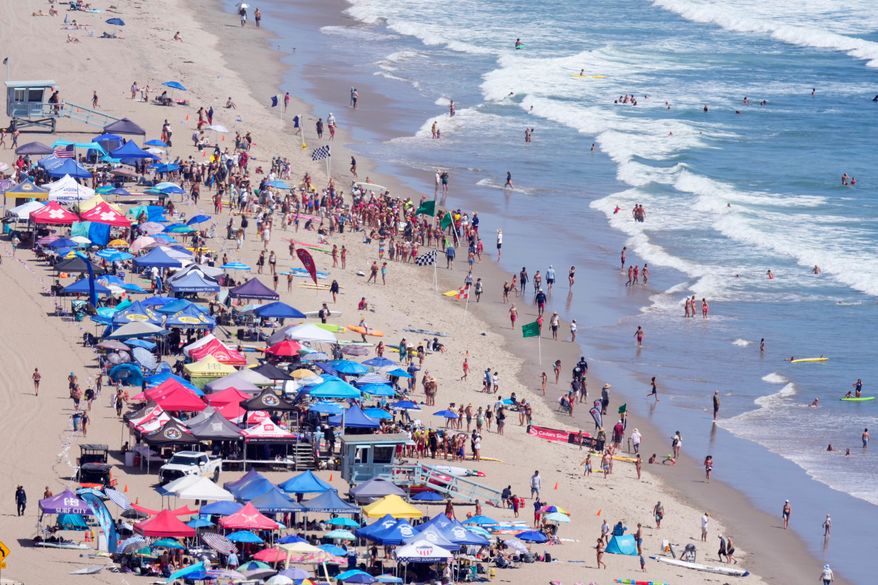 Beach goers watch during the the 46th Annual California Surf Lifesaving Championships on Will Rogers State Beach Friday, July 24, 2026, in the Pacific Palisades section of Los Angeles. (AP Photo/Mark J. Terrill)