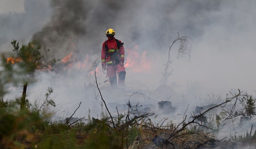 Firefighters battle a wildfire near Marcheprime, outside, Bordeaux, France, Sunday, July 26, 2026. (AP Photo/Emma Da Silva)