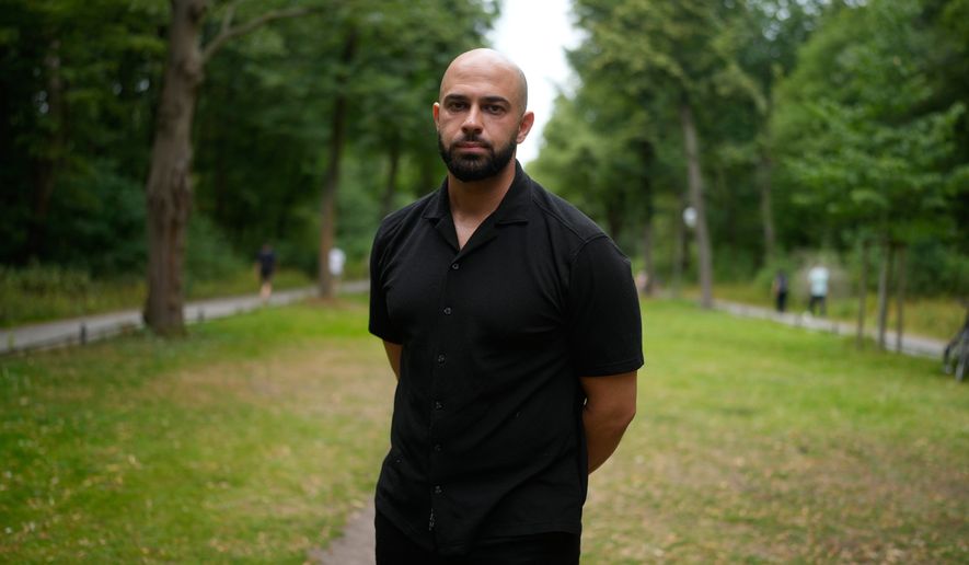 Police officer Ali Darwich poses for a portrait near the scene where a car rammed into a crowd at the Pride March in Berlin, Germany, Sunday, July 26, 2026. (AP Photo/Markus Schreiber)