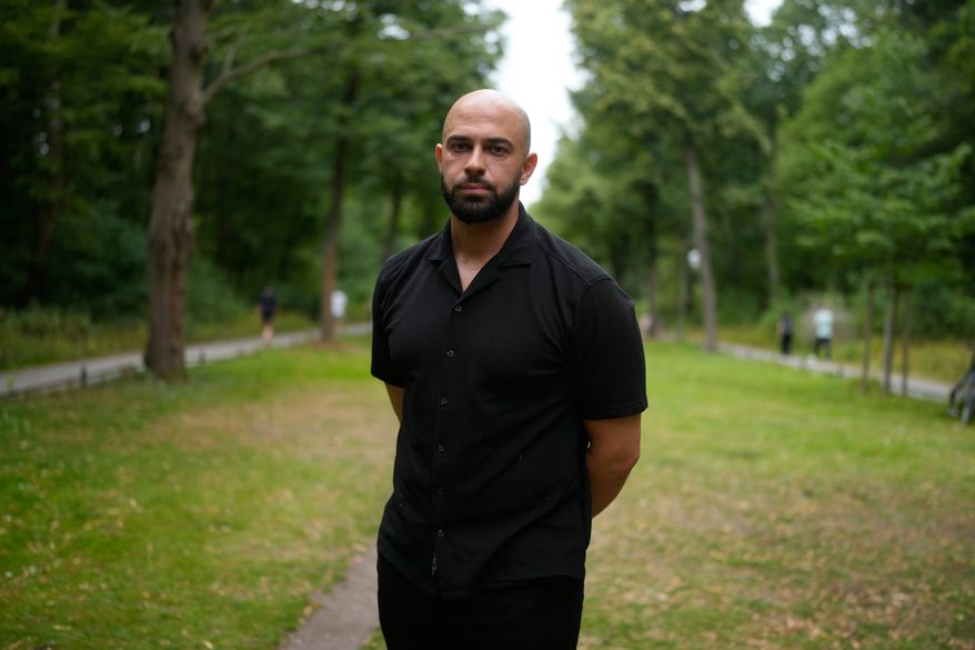 Police officer Ali Darwich poses for a portrait near the scene where a car rammed into a crowd at the Pride March in Berlin, Germany, Sunday, July 26, 2026. (AP Photo/Markus Schreiber)