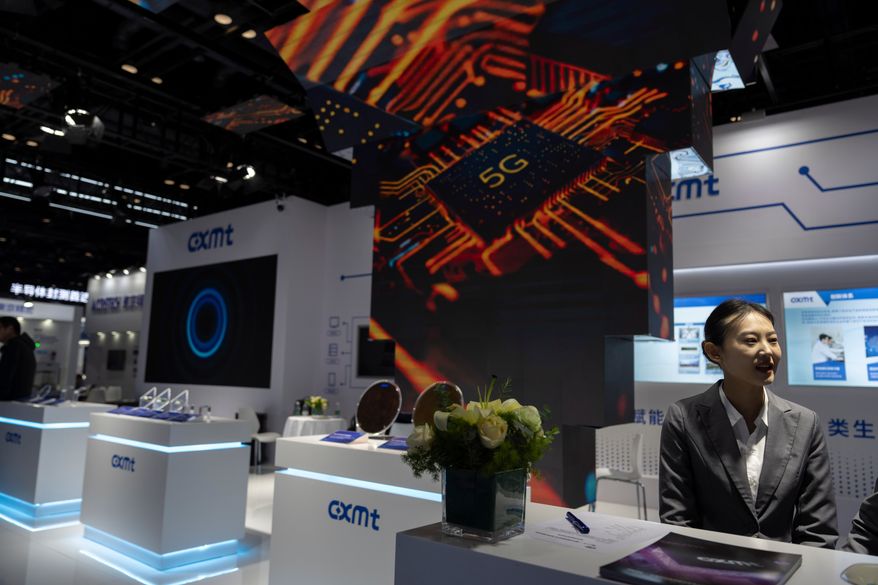 A worker at the booth for Chinese DRAM producer ChangXin Memory Technologies, also known as CXMT, waits for visitors at the 21st China International Semiconductor Expo in Beijing, Nov. 20, 2024. (AP Photo/Ng Han Guan, File)