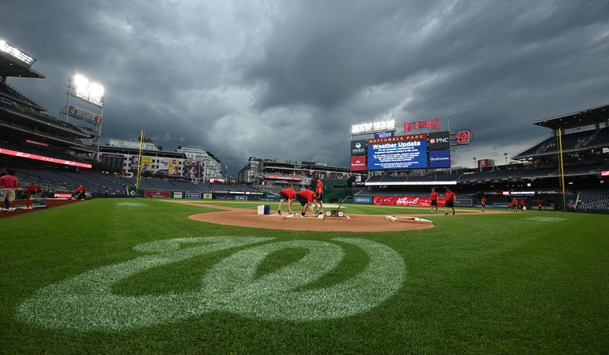 The Washington Nationals grounds crew works on the field as the baseball game between the Washington Nationals and the Toronto Blue Jays is being delayed due to inclement weather in the area, Tuesday, July 28, 2026, in Washington. (AP Photo/Nick Wass)