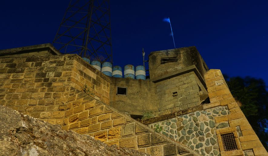 Embrasures and barrels are part of the medieval walls at the Paphos Gate next to the U.N. buffer zone separating the Greek Cypriot south from the Turkish Cypriot north, established after the July 20, 1974 Turkish invasion of Cyprus, in the medieval core of the divided capital of Nicosia, Cyprus, on July 16, 2026. (AP Photo/Petros Karadjias)