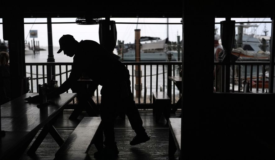 A Haitian worker with Temporary Protected Status cleans tables at Half Shell Raw Bar, Friday, July 24, 2026, in Key West, Fla. (AP Photo/Rebecca Blackwell)